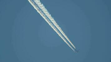 contrails in de blauwe lucht. vliegtuig dat hoog vliegt. video