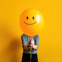 Person holding a balloon. Unrecognizable person holding yellow balloon against orange. AI Generated photo