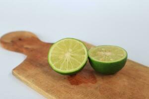 A sliced lime on a cutting board on a white background photo