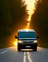 A van driving down a road with the sun setting behind it photo