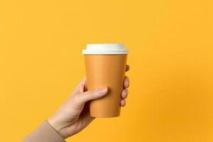 Generative AI illustration of paper coffee cup in a hand, isolated yellow background photo