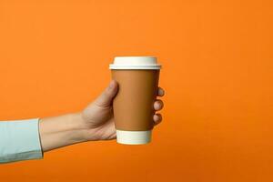 Generative AI illustration of paper coffee cup in a hand, isolated orange background photo