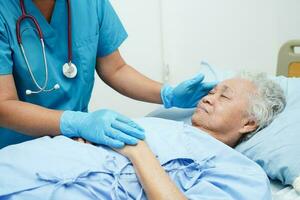 Doctor taking care, help and encourage Asian elder senior woman patient in clinic hospital. photo