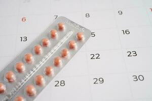 Birth control pills for female on calendar, ovulation day. photo