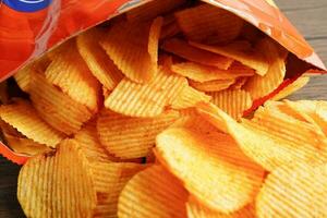 Potato chips in open bag, delicious BBQ seasoning spicy for crips, thin slice deep fried snack fast food. photo