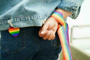 Asian woman with rainbow flag, LGBT symbol rights and gender equality, LGBT Pride Month in June. photo