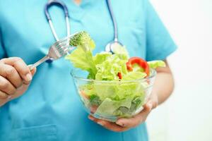 Asian Nutritionist holding healthy food for patient in hospital, nutrition and vitamin. photo