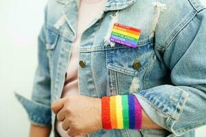 mujer asiática con bandera del arco iris, derechos de símbolos lgbt e igualdad de género, mes del orgullo lgbt en junio. foto