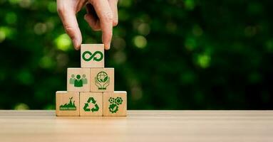 circular economy icons in wooden cubes. economic system that aims to minimize waste and maximize resource efficiency, sustainable strategies to eliminate waste and pollution for future business growth photo
