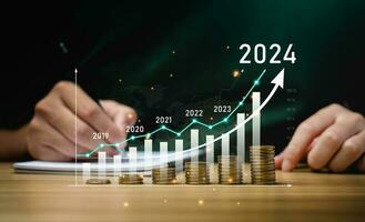 financial business growth 2024 concept. businessperson calculate income and profit on investments and an increase in the indicators of positive growth, with virtual holographic chart graph. rich, coin photo