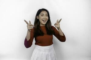 Excited Asian woman wearing red t-shirt, pointing at the copy space on top of her, isolated by white background photo