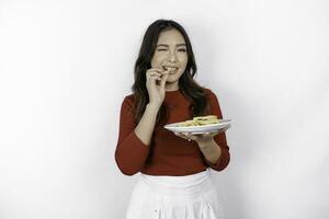 imagen de sonriente joven asiático niña comiendo francés papas fritas aislado en blanco antecedentes foto