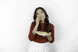 Image of smiling young Asian girl eating french fries isolated on white background photo