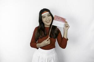 Excited young Asian woman celebrate Indonesian independence day holding the Indonesian flag isolated on white background photo