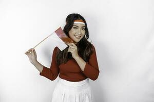 Excited young Asian woman celebrate Indonesian independence day holding the Indonesian flag isolated on white background photo