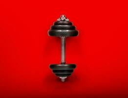 Steel dumbbells, isolated on red background photo