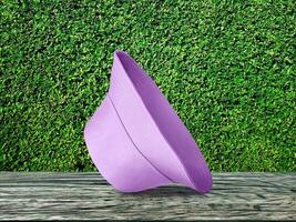 purple bucket hat on table wooden background There is a green garden background. photo