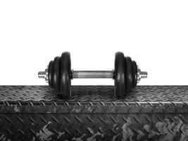 The dumbbell is placed on a metal plate. isolated on white background photo