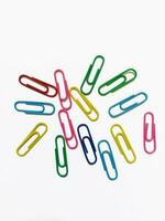 multi-colored paper clips on a white background photo