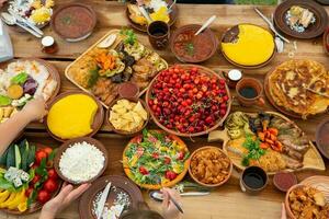 Homemade Romanian Food with grilled meat, polenta and vegetables Platter on camping. Romantic traditional moldavian food outside on the wood table. photo