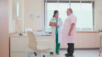 hembra médico y profesional nutricionista en uniforme asesorar caucásico pacientes a estar ponderación de grasas y examinar para sano dieta a clínica hospital, chequeos, y equipo. video