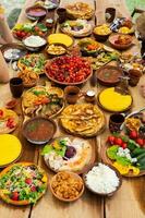 Homemade Romanian Food with grilled meat, polenta and vegetables Platter on camping. Romantic traditional moldavian food outside on the wood table. photo