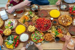 Homemade Romanian Food with grilled meat, polenta and vegetables Platter on camping. Romantic traditional moldavian food outside on the wood table. photo