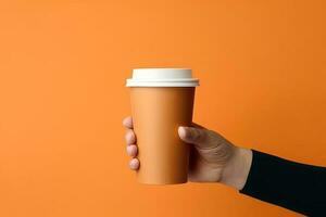 Generative AI illustration of paper coffee cup in a hand, isolated orange background photo