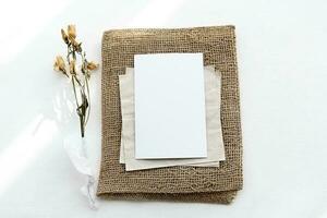 An envelope made of kraft paper and a white blank card on a white table photo