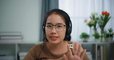 Young Asian woman wearing glasses using a laptop on a desk photo