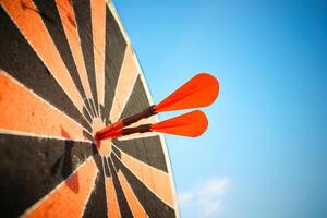 red darts arrows in the target center on blue sky background. Business target and success concept. photo