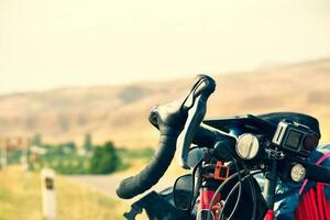 Drop bar touring bicycle stand close up with action camera attached to frame .Bicycle touring outdoors in nature photo