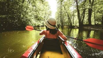 Back view Kayaking couple in river. POV of woman and man kayaking in beautiful landscape. Aquatic sports during fall autumn concept.Beautiful calm relaxing warm scenic trees autumn photo