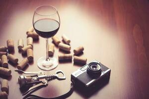 Retro camera and wine on wood table background. photo