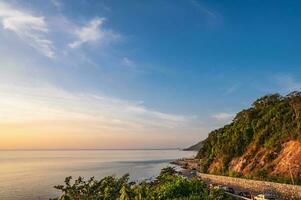 Beautiful seascape view with the mountain and sunset at noen nangphaya viewpoint chanthaburi thailand.Popular waterfront photo spot with a backdrop of the curving coastal road