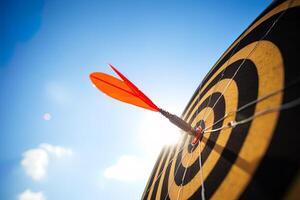 red darts arrows in the target center on blue sky background. Business target and success concept. photo