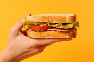 Hand holding tasty sandwich on a yellow background. ai generated photo