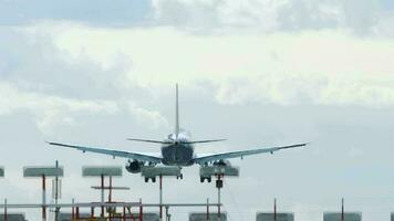 silueta de avión aterrizaje a el aeropuerto a en contra un nublado cielo. lento movimiento. posterior ver video