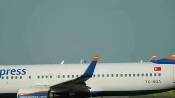 DUSSELDORF, GERMANY JULY 22, 2017 - SunExpress Boeing 737, TC SOA taxis at the start of the runway before departure. An airplane takes off in the background. Runway at Dusseldorf airport DUS video