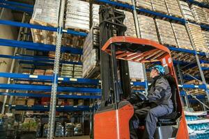 Storehouse employee during driving on forklift in warehouse photo