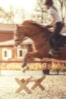 Fast Horse rider jumping above fence. photo