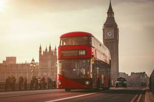 Red London Bus on the Westminster Bridge and Big Ben Tower in the background. photo