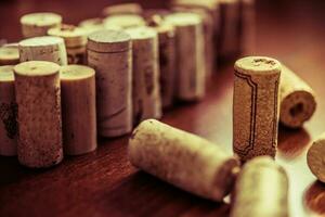 Wine corks on wooden table background closeup photo. photo