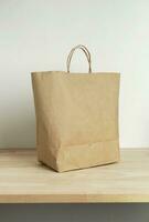 brown paper bag on wooden table for mockup blank template photo