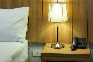 mesa lámpara en cabecera en el dormitorio foto