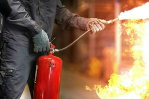 Man using fire extinguisher fighting fire closeup photo. photo