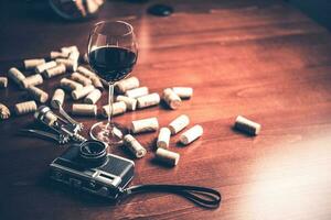 Retro camera and wine on wood table background. Vintage concept. photo