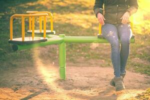 Girl siting on kids carousel photo