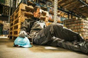 Exhausted warehouse worker lying on the ground photo