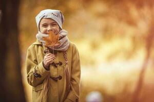 joven niña sonriente con otoño hoja foto